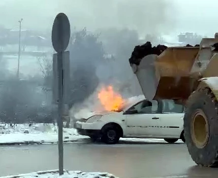 Otomobildeki yangını, iş makinesiyle toprak dökerek söndürdü